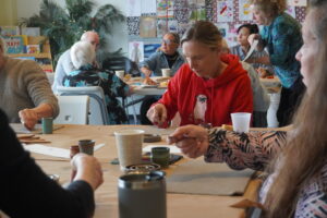 A group of people working on a pottery project in an art workshop.