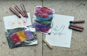 Colourful oil pastels and sheets of paper.