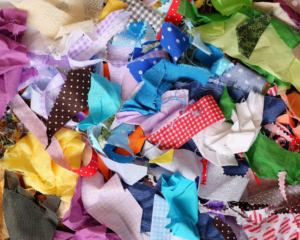A pile of colourful fabric scraps in a variety of sizes.